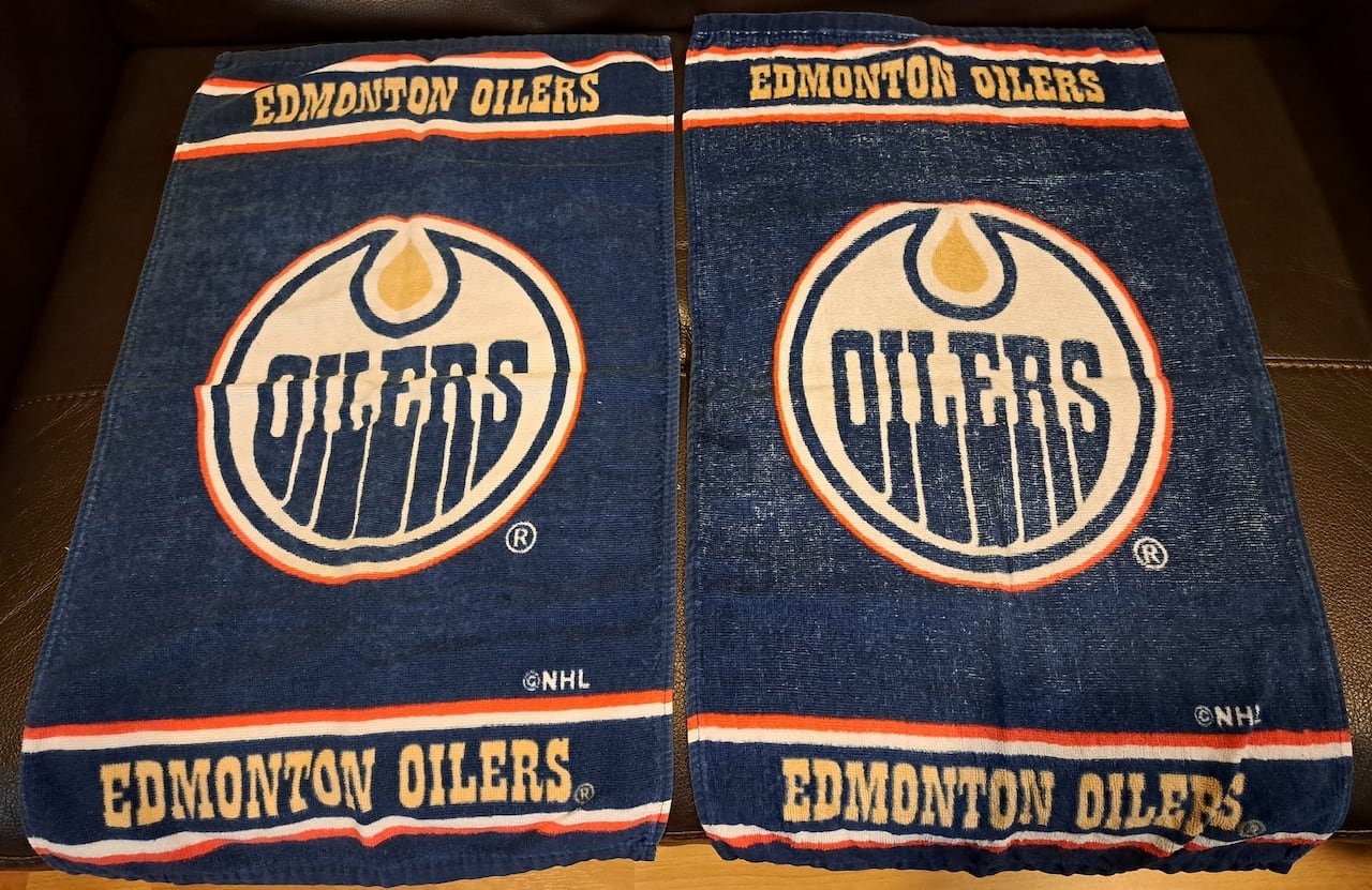 default-360 Two blue towels featuring 'Oilers' logos, symbolizing Erlinda Tan's early affinity for NHL hockey while residing in Edmonton.